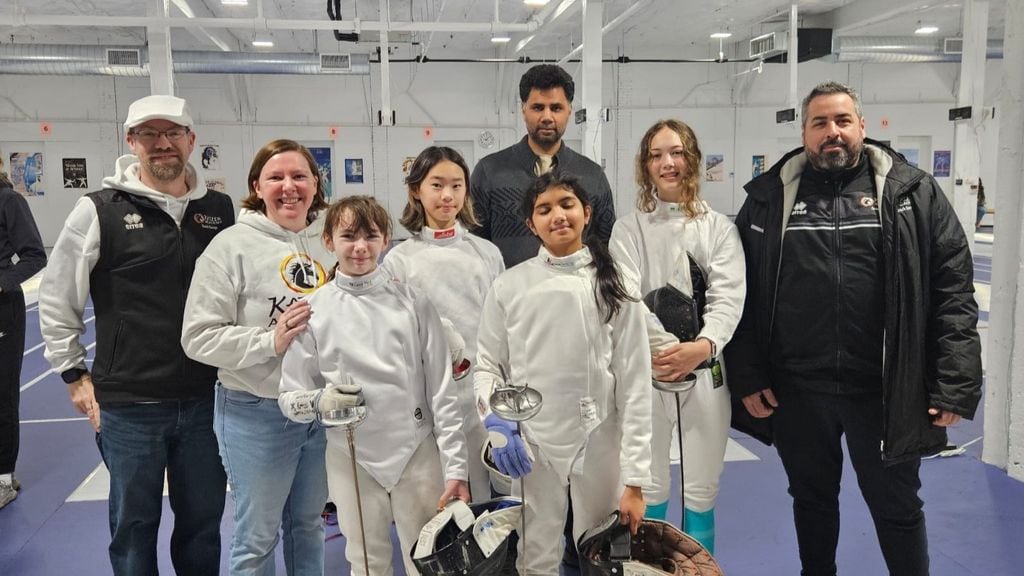A group of young fencers with coaches.
