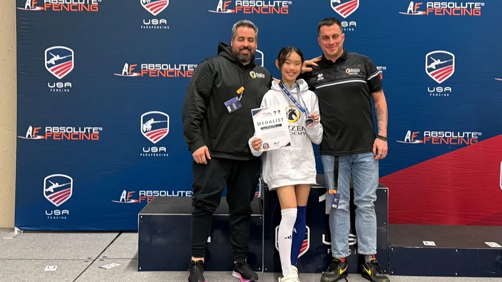 Fencing coaches standing with a student